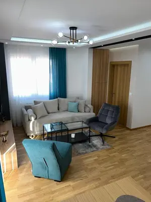 a living room with a couch and a chair at Perla Lux 2 Apartments in Arandjelovac