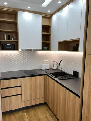 a kitchen with white cabinets and a black counter top at Perla Lux 2 Apartments in Arandjelovac