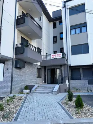 a building with stairs and a sign in front of it at Perla Lux 2 Apartments in Arandjelovac