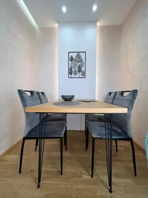 a dining room table with chairs and a bowl on it at Perla Lux 2 Apartments in Arandjelovac