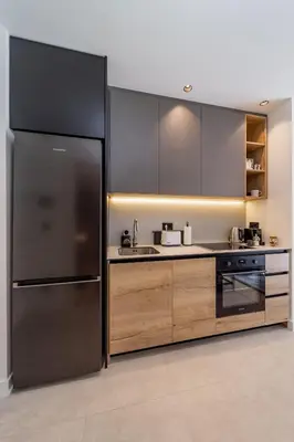 a kitchen with a stainless steel refrigerator and wooden cabinets at Chic Studio on the Belgrade's Waterfront in Belgrade