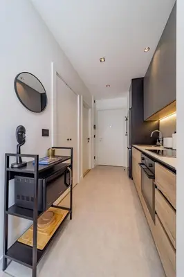 a kitchen with black cabinets and a counter top at Chic Studio on the Belgrade's Waterfront in Belgrade