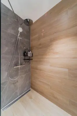 a bathroom with a shower with a wooden wall at Chic Studio on the Belgrade's Waterfront in Belgrade