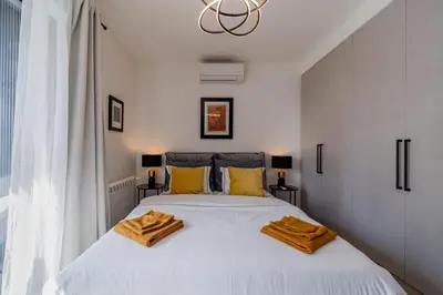 a bedroom with a white bed with yellow pillows at Chic Studio on the Belgrade's Waterfront in Belgrade
