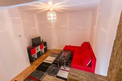 a living room with a red chair and a tv at Top of Pop in Belgrade