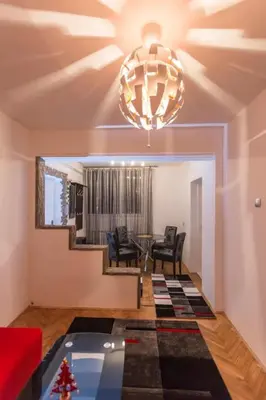 a living room with a table and chairs and a chandelier at Top of Pop in Belgrade