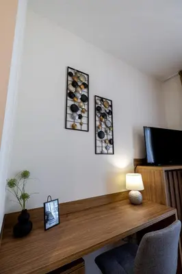 a room with a wooden desk with a tv and a table at inJoy in Sajmište