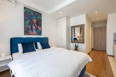 a bedroom with a large bed with a blue headboard at inJoy in Sajmište