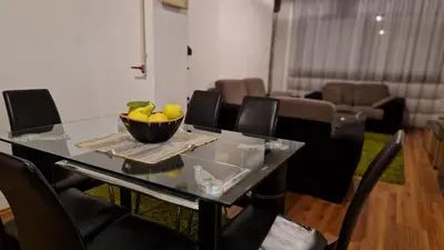 a dining room table with a bowl of fruit on it at Apartman Dunja in Ruma