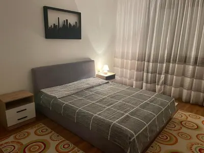 a small bedroom with a bed and a night stand at Apartman Dunja in Ruma