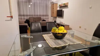 a bowl of lemons sitting on a glass table at Apartman Dunja in Ruma