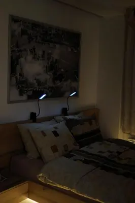 a bedroom with a couch and two lights on the wall at Garden Oasis in Belgrade