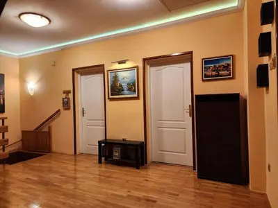 a living room with two doors and a wooden floor at Earth & Sky apartment in Sajmište
