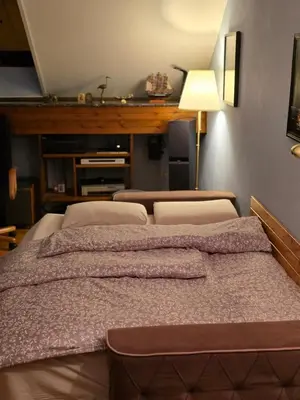 a large bed in a room with a lamp at Earth & Sky apartment in Sajmište