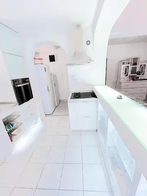 a white kitchen with white appliances and white tile floors at Vila Avala in Belgrade