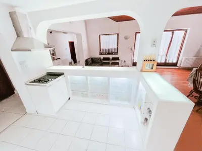 a kitchen with white cabinets and a white tile floor at Vila Avala in Belgrade