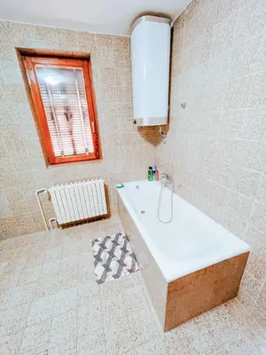 a bathroom with a bath tub and a window at Vila Avala in Belgrade