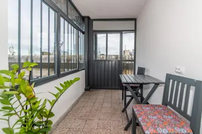 a balcony with a table and a bench and windows at 7 Heaven in Belgrade