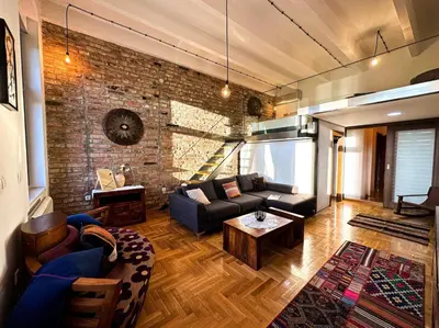 a living room with a couch and a brick wall at Friends Loft with Terrace & River View Old Town in Belgrade