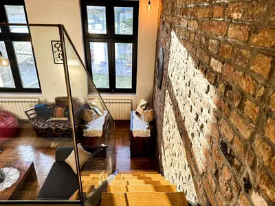 a living room with a brick wall and a mirror at Friends Loft with Terrace & River View Old Town in Belgrade