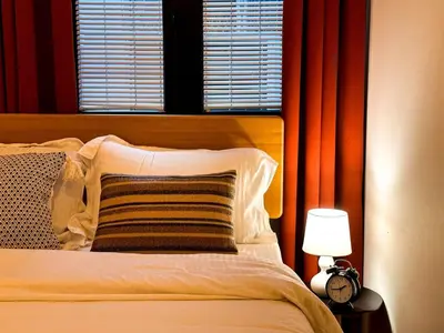 a bed with a pillow and a lamp next to a window at Friends Loft with Terrace & River View Old Town in Belgrade