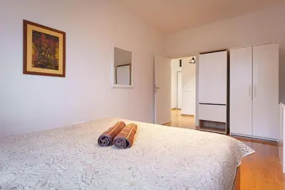 a bedroom with a white bed with two brown shoes on it at Yellow Lux apartment in Novi Beograd