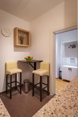 a kitchen with a table and two chairs and a counter at Yellow Lux apartment in Novi Beograd