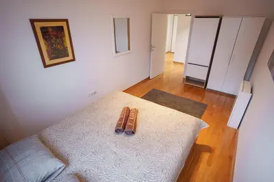 a bedroom with a bed with two slippers on it at Yellow Lux apartment in Novi Beograd