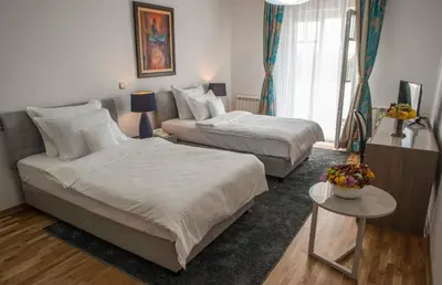 a hotel room with two beds and a table at Hotel Radmilovac in Belgrade