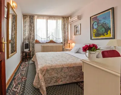 a hotel room with a bed and a window at Hotel Radmilovac in Belgrade