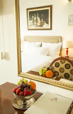a bowl of fruit on a table in front of a mirror at Hotel Radmilovac in Belgrade
