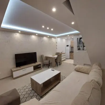 a living room with a couch and a tv at Apartman LUX Jelena in Surčin