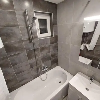 a bathroom with a bath tub and a sink at Apartman LUX Jelena in Surčin