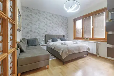 a bedroom with a bed and a couch at Relax Home Downtown Apartment in Belgrade