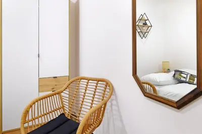 a mirror hanging on a wall next to a chair at Apartment Paradise Nice Home in Belgrade