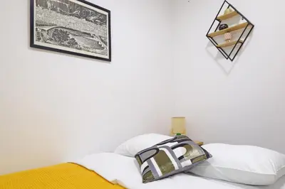 a bedroom with white walls and a bed with white pillows at Apartment Paradise Nice Home in Belgrade