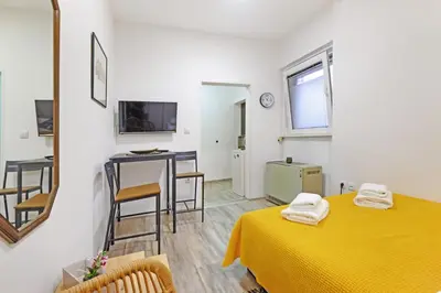 a room with a bed and a table with a yellow blanket at Apartment Paradise Nice Home in Belgrade