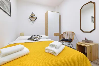 a bedroom with a yellow bed with towels on it at Apartment Paradise Nice Home in Belgrade