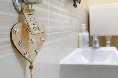 a wooden heart on the wall next to a sink at Apartment Paradise Nice Home in Belgrade