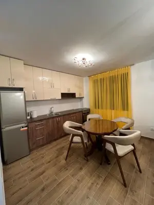 a kitchen with a table and chairs and a refrigerator at STAN NA DAN MILA in Irig