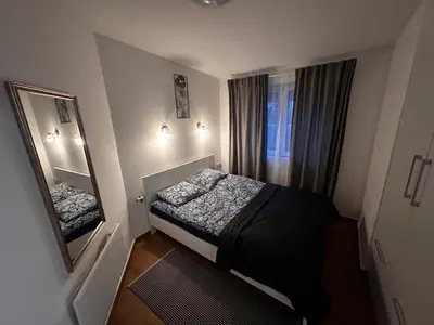 a small bedroom with a bed and a mirror at Apartman Savamala Promenada 57 in Belgrade