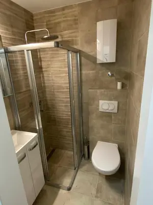 a bathroom with a shower and a toilet and a sink at Apartman Savamala Promenada 57 in Belgrade