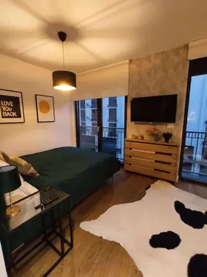 a bedroom with a large green bed and a television at Aria in Belgrade