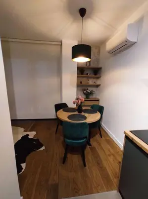 a room with a table and chairs and a cow on the floor at Aria in Belgrade