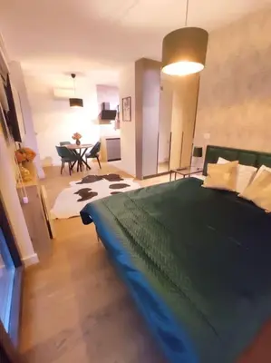 a bedroom with a large bed and a dining room at Aria in Belgrade