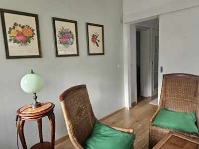 a living room with two chairs and a lamp on a table at Apartment Olga in Vračar (historical)