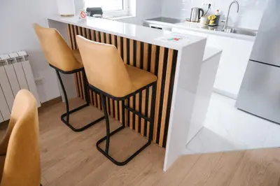 a kitchen with a counter with two stools at Nika apartman in Surčin