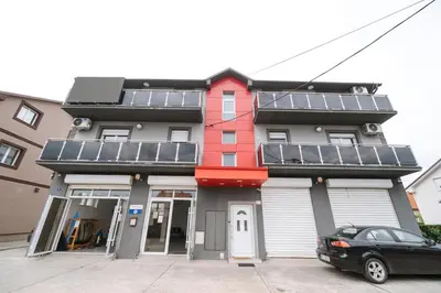 a red building with solar panels on it at Nika apartman in Surčin