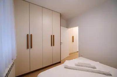 a bedroom with white cabinets and a bed at Nika apartman in Surčin