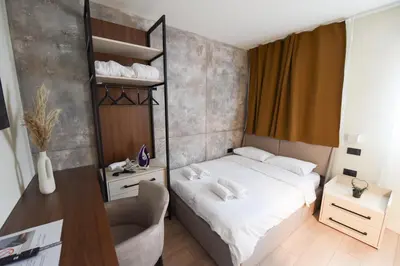 a small bedroom with a bed and a desk at HOTEL Iva Old Town in Belgrade